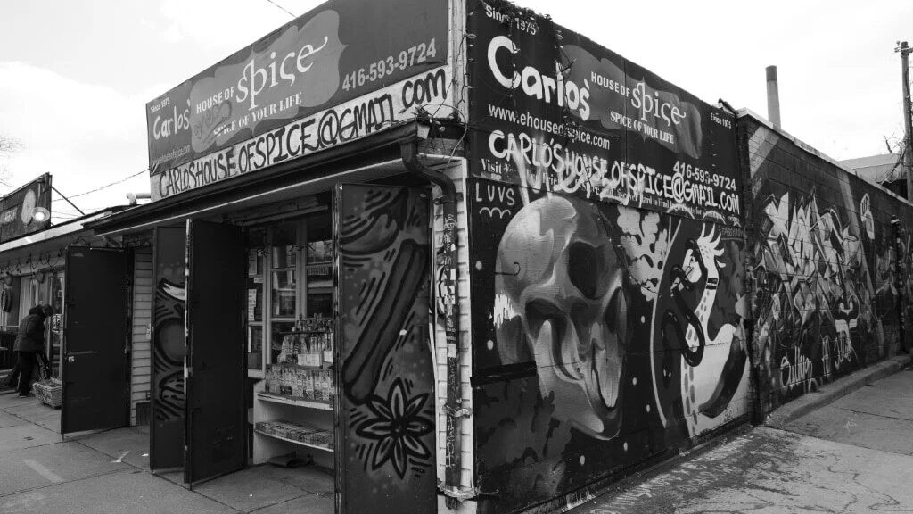 Black-and-white press photo of the storefront corner on Augusta Ave
